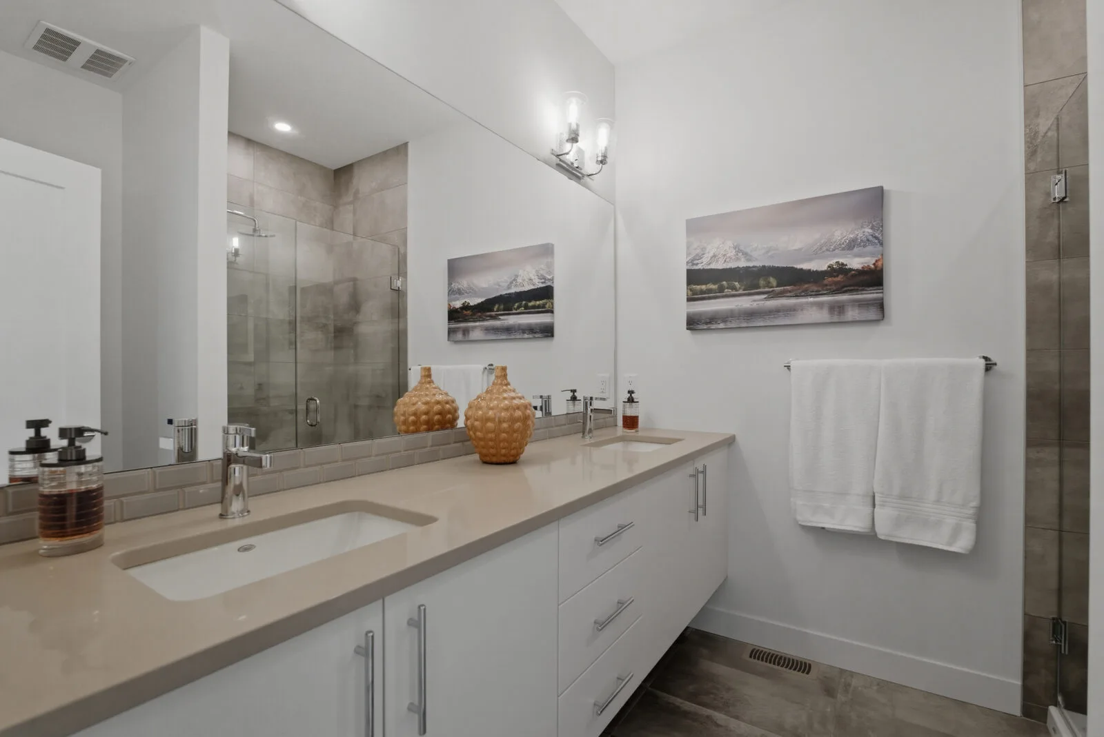 Bathroom with a double vanity and custom glass shower at Academy Ridge